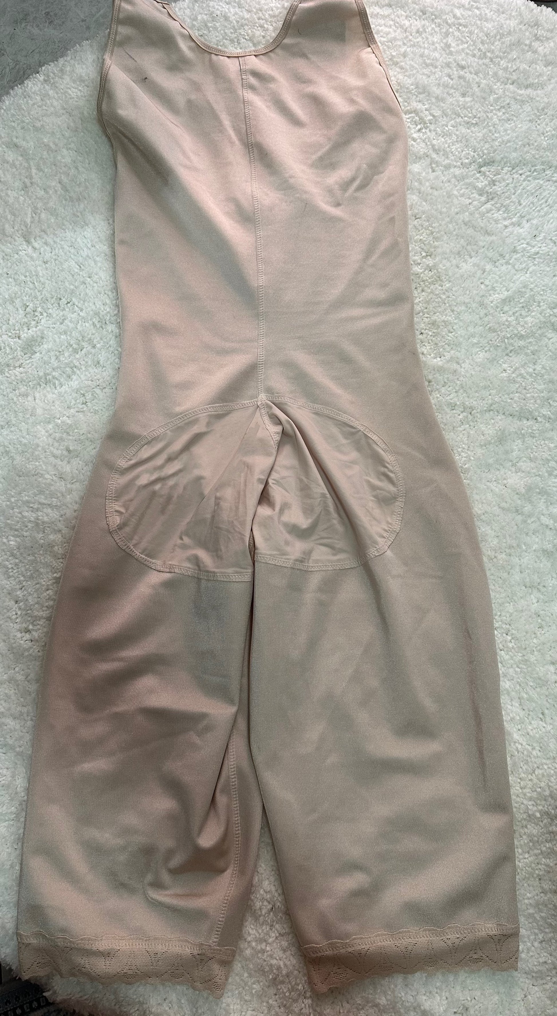 Beige jumpsuit on a textured surface